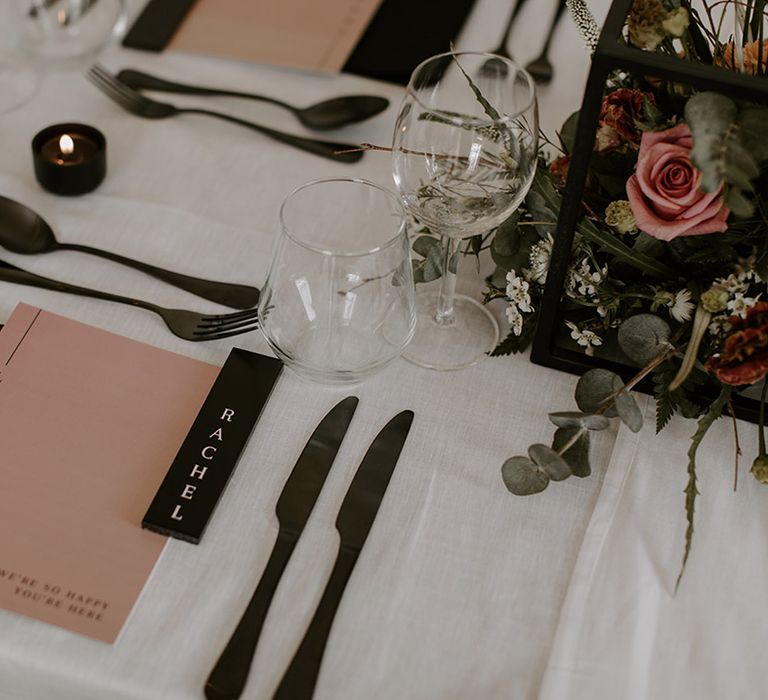 Pink and black wedding theme with pink wedding menus, black napkins, black cutlery, black place names and black candle holders 