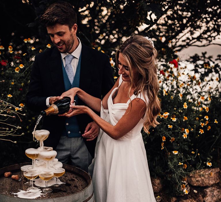 bride pouring champagne into the coupe glass champagne tower 