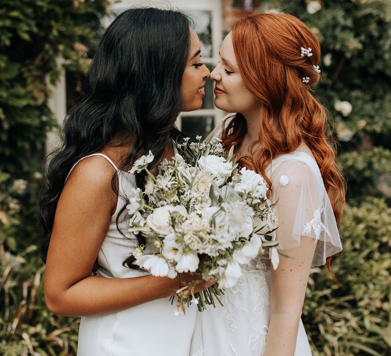 Brides hold white wedding bouquets for minimalist monochrome wedding 