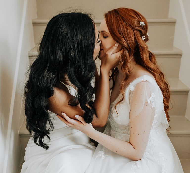 Two brides sharing a kiss on their wedding day at Lyde Court 