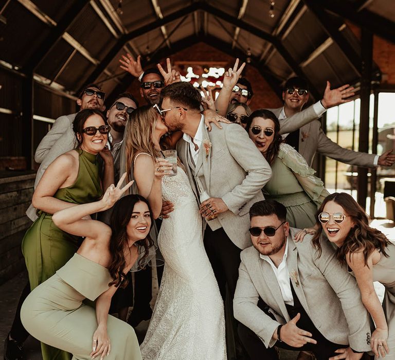 Wedding party wearing green wedding outfits and bridesmaid dresses with sunglasses for wedding party photos 