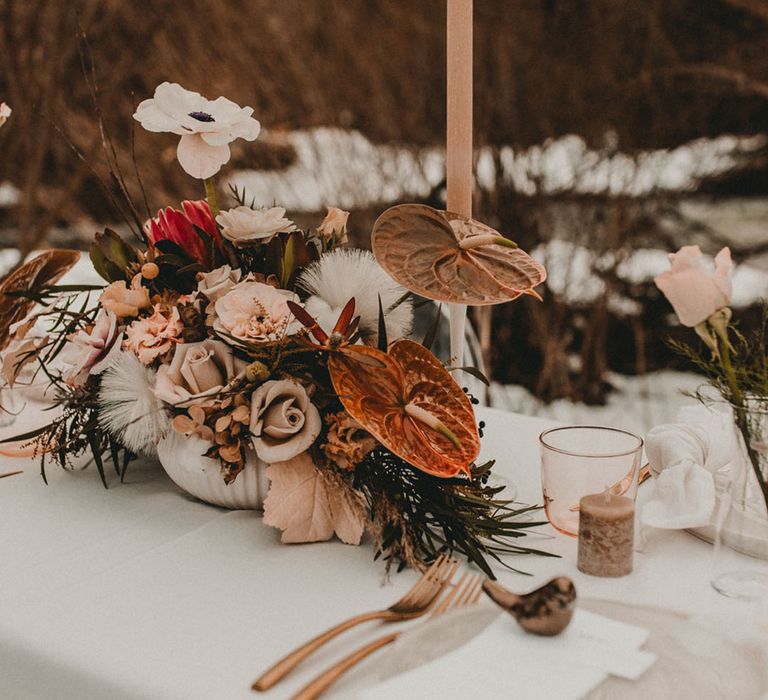 Outdoor wedding breakfast in snowy landscape with neutral brown wedding flowers and more