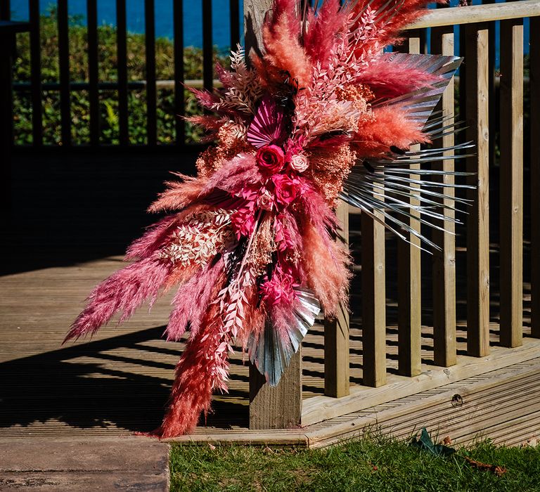 Hot pink, coral and silver wedding flower decoration with pampas grass and other dried flowers 