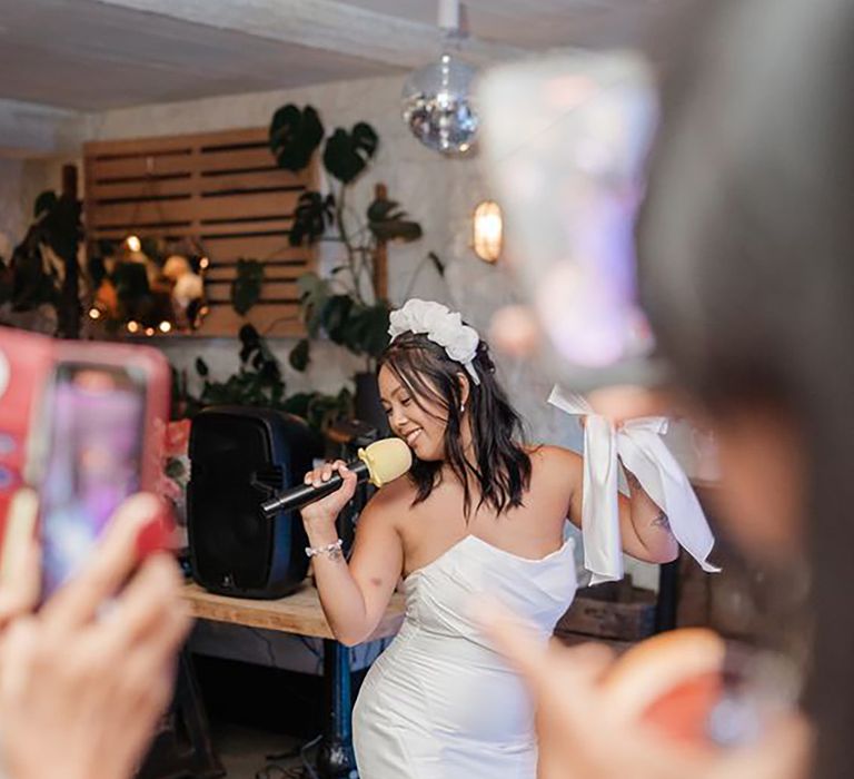 Bride singing karaoke at wedding reception 