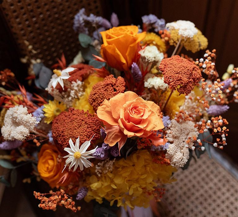 Summer wedding bouquet with a bold colour palette of orange, yellow and lilac flowers 