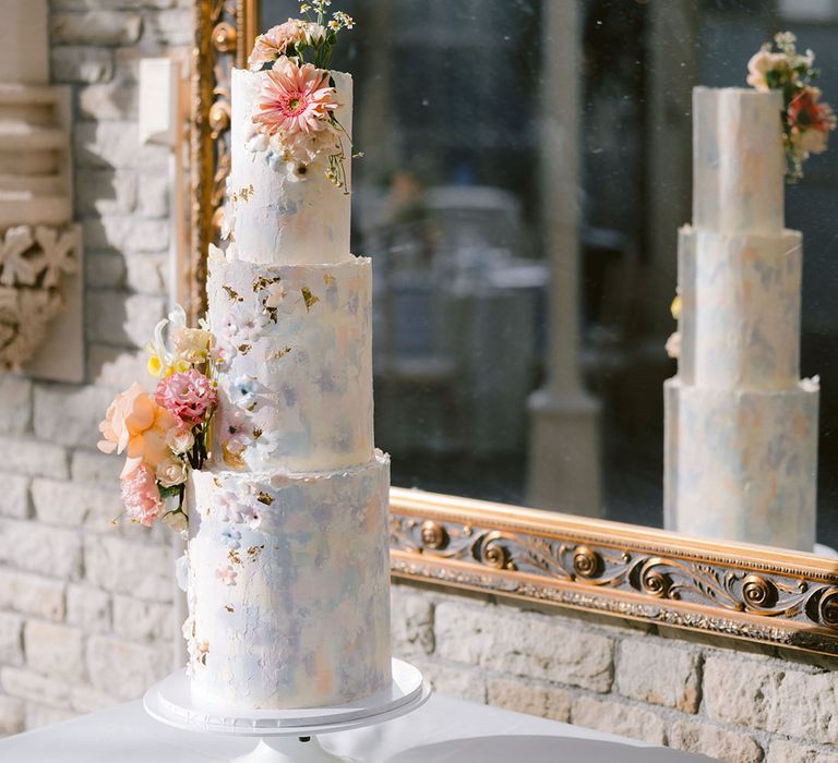 Three tiered traditional wedding cake with watercolour style painted wedding cake with pastel colours 