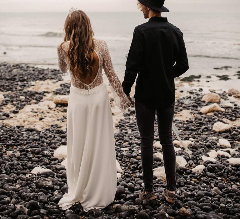 Bride in wedding dress with low back a bell sleeves in lace 