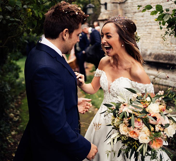 Newly wed couple celebrating with confetti and off the shoulder wedding dress