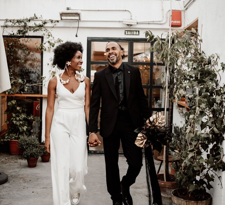 Bride & groom walk hand in hand 