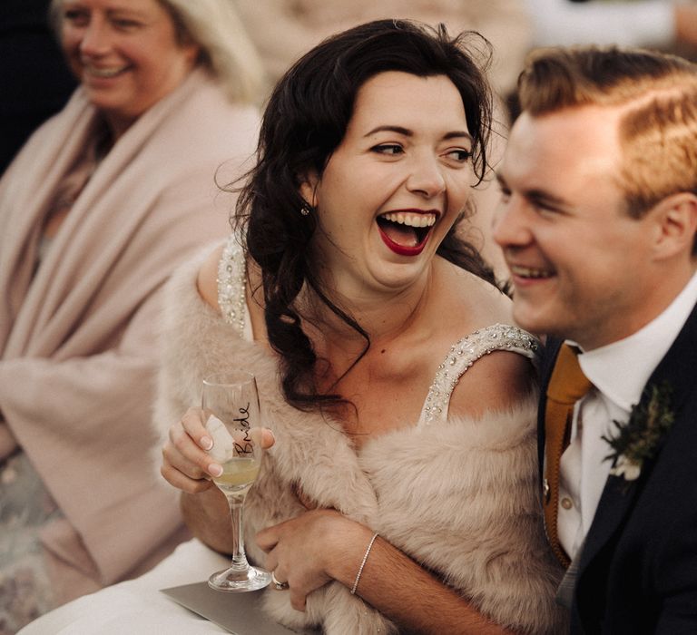 Bride & groom laugh during wedding reception speeches