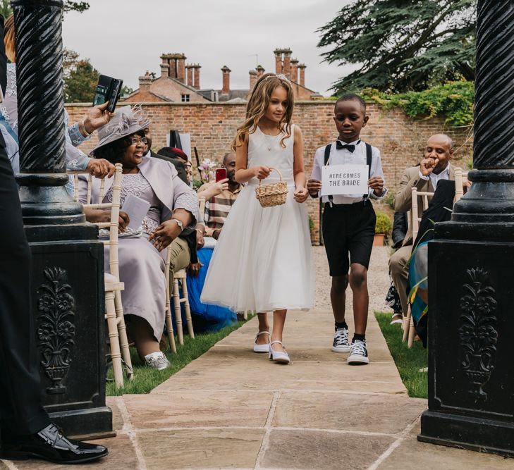 Flower girl and page boy walking down the aisle 