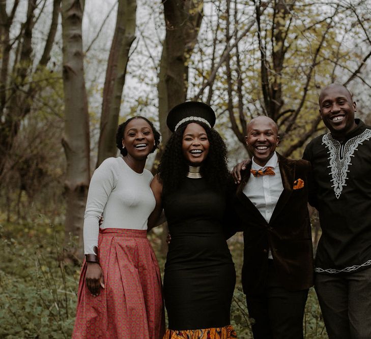 Bride and groom with their wedding guests in the woods 