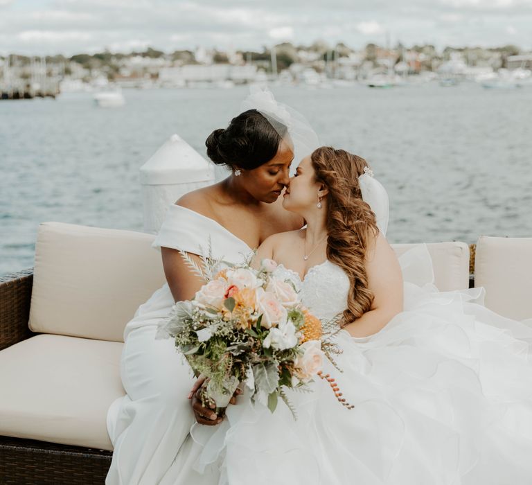 Two brides kissing on the dock at their Rhode Island Marina wedding 