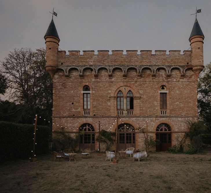 Château de Caumont castle orangery with festoon lit outdoor seating area