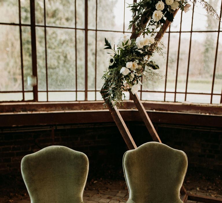 Green velvet wedding chairs at the altar 