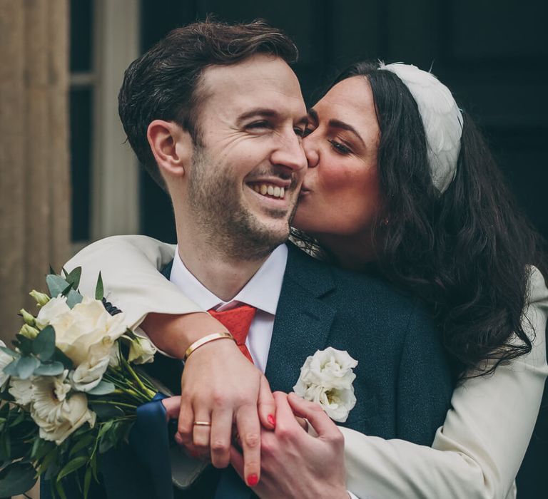 Bride kissing groom - bride wears red nail polish to match grooms red tie