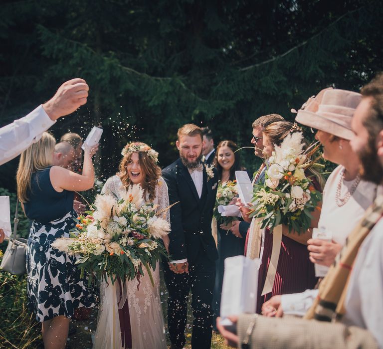 Bride & groom walk through confetti 