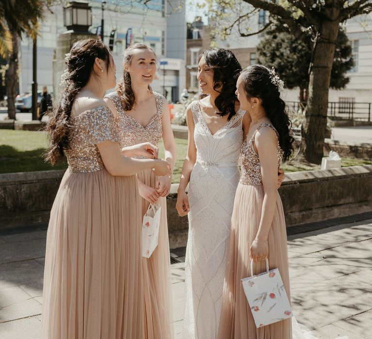 Bride and her bridesmaids, they are wearing blush gowns with sequin top detailing and tulle skirts