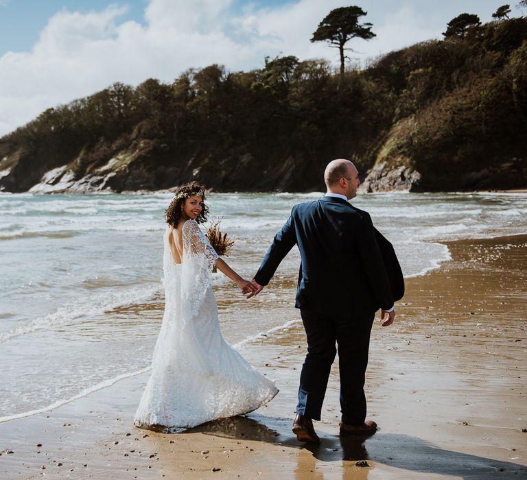 Bride & groom walk together along the beach front in Cornwall for wedding elopement