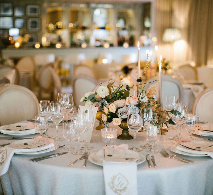 Round wedding reception tables at Grantley Hall wedding venue with taper candles and floral centrepiece arrangement 