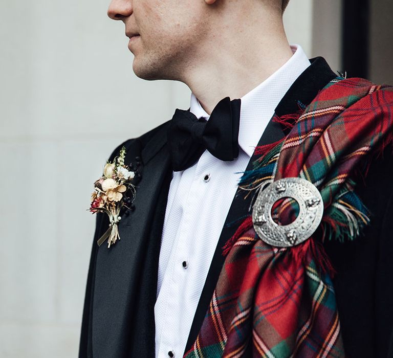 Groom outfit details with bowtie and dried flower buttonhole