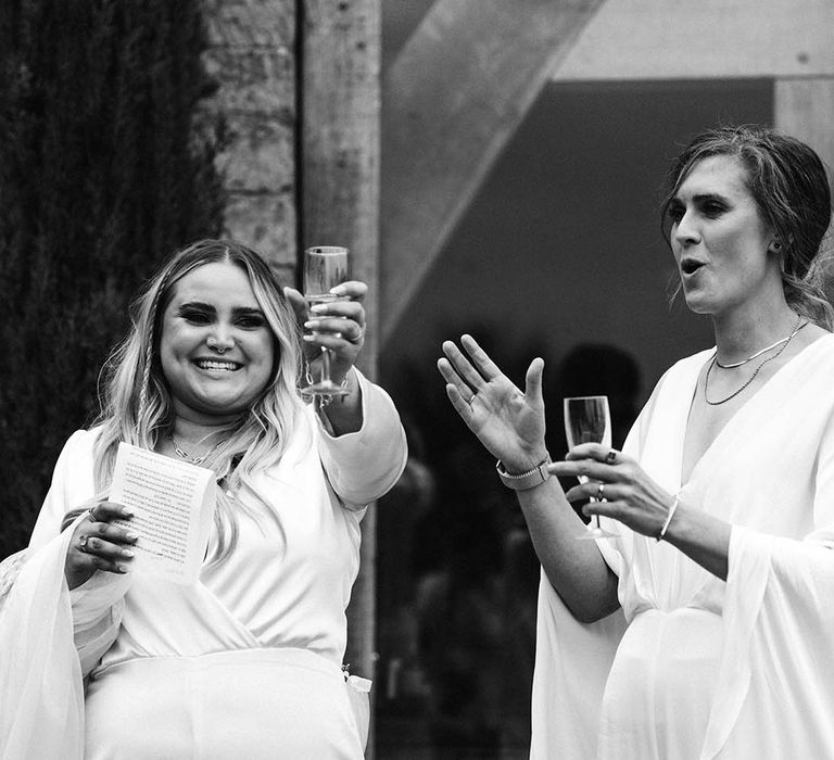 Black & white image of brides celebrating outdoors on their wedding day