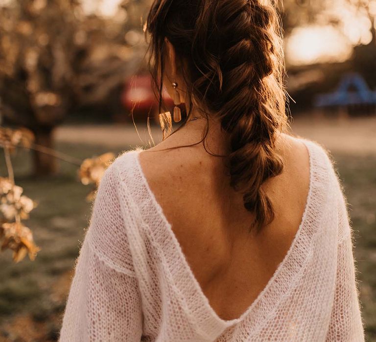 Bride in a jumper with her hair up in a loosely pinned braid