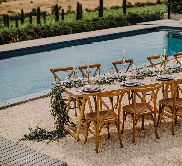 Rustic table setting next to pool complete with golden fields to the background