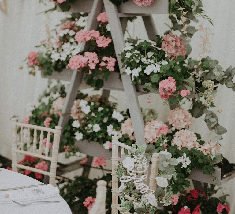 Grey step ladder and planter wedding decor with pink and white flowers and plants for back garden wedding 