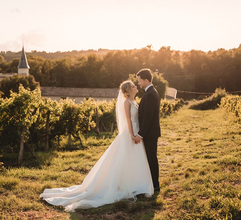 Romantic golden hour portrait in a vineyard at Chateau Lagorce with bride in a princess wedding dress