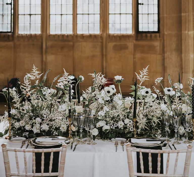 Wedding table decor with black plates and white flower centrepiece