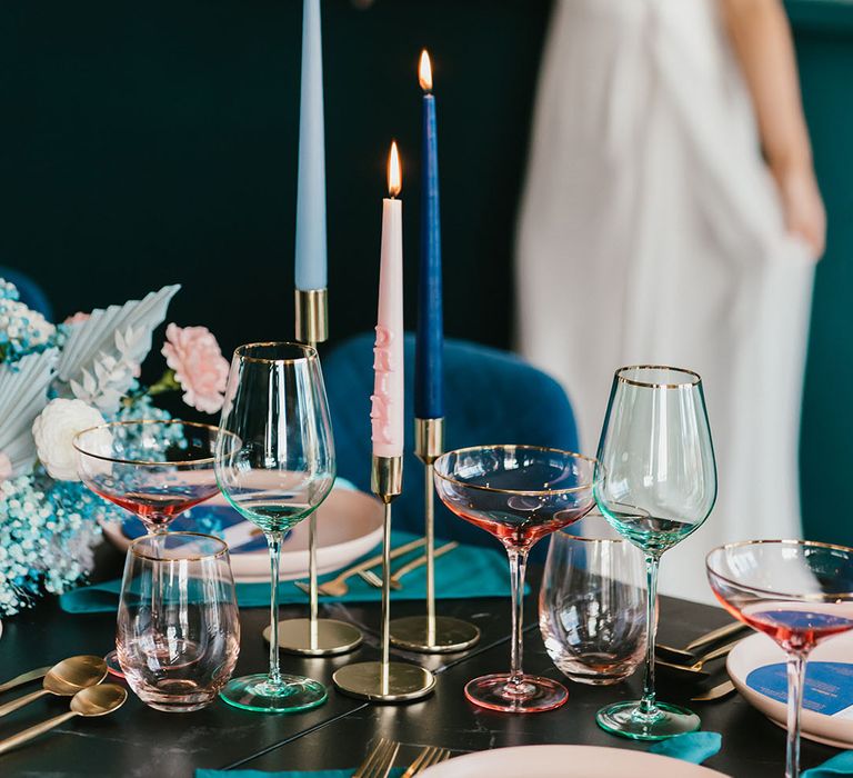 pink, navy blue and teal green wedding table decor with coloured glass and taper candles 