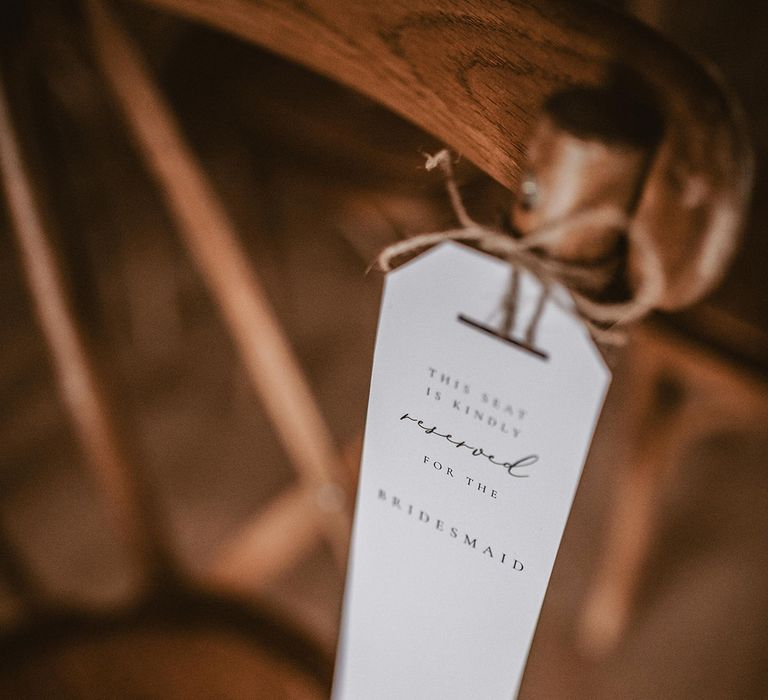 Reserved sign for bridesmaid hangs off chair