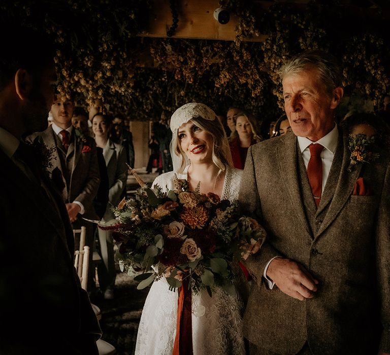 Father of the bride in a brown wool suit walking his daughter down the aisle in a lace wedding dress at her Lyde Court wedding 