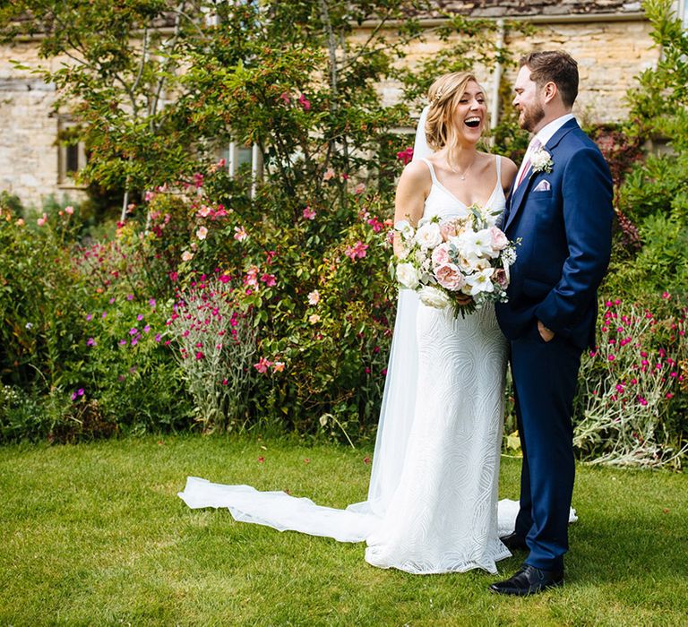 Summer Caswell House wedding with Bride in a beaded wedding dress, groom in a navy suit and white and pink wedding flowers 