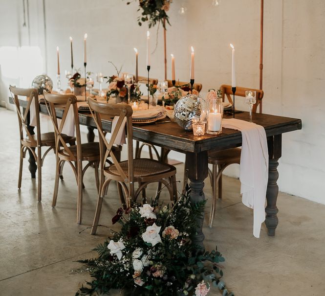 Rustic yet modern tablescape complete with candle lights and floral decor on wooden table