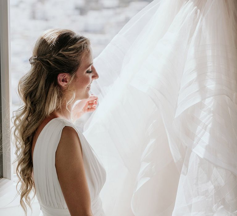 Bride looks at her Watters wedding gown