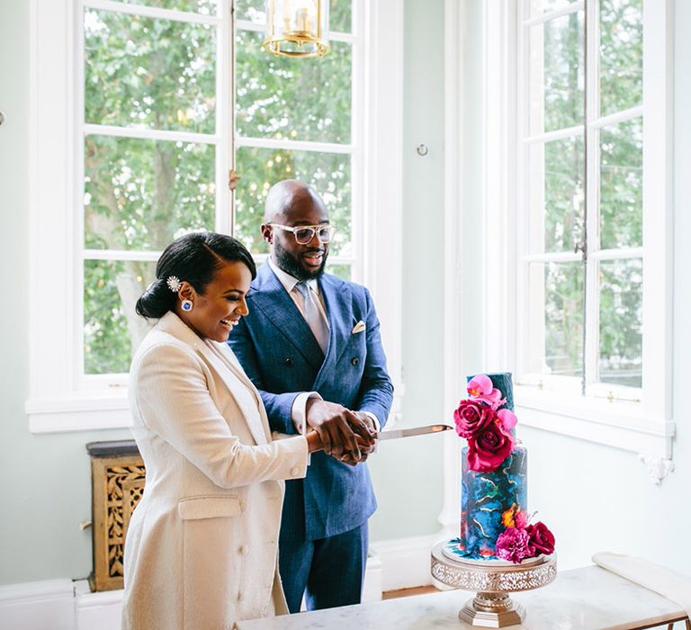 Bride & groom cut blue marble wedding cake on their wedding day