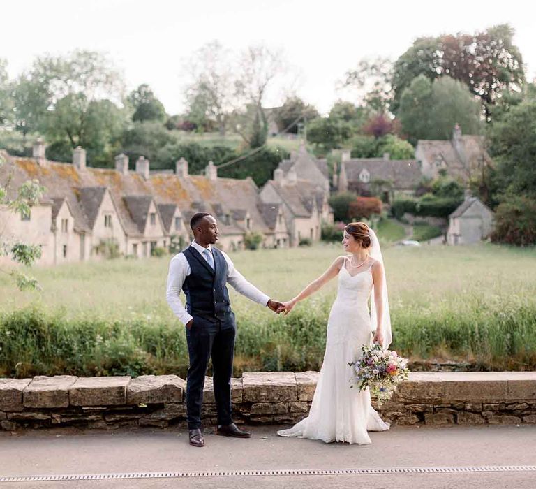 Bride & groom stand in front of countryside on their wedding day