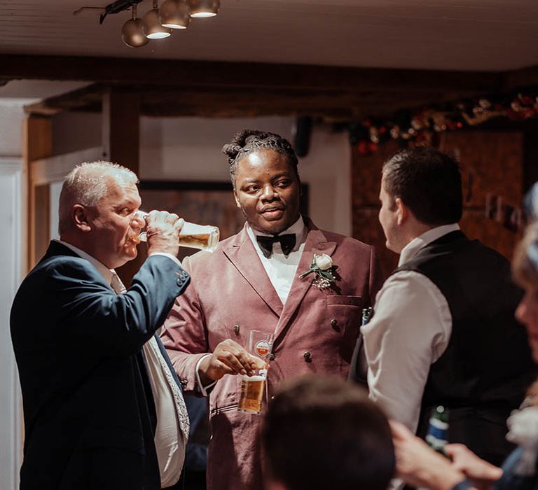 Wedding guests mingle with groom during wedding reception