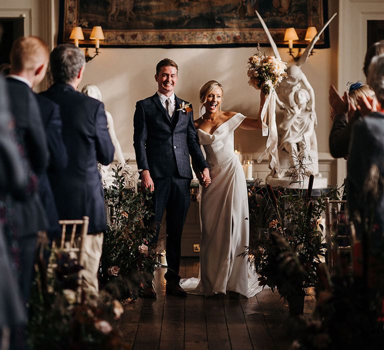 Bride and groom face their wedding guests as husband and wife 