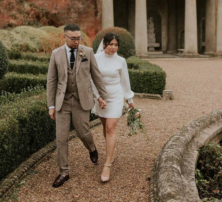 Bride and groom hand in hand at Leatherhead Registry Office 