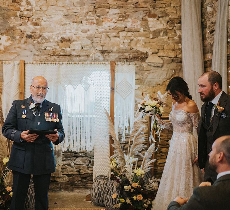 The groom's father hosts the non-denominational wedding ceremony in his RAF uniform