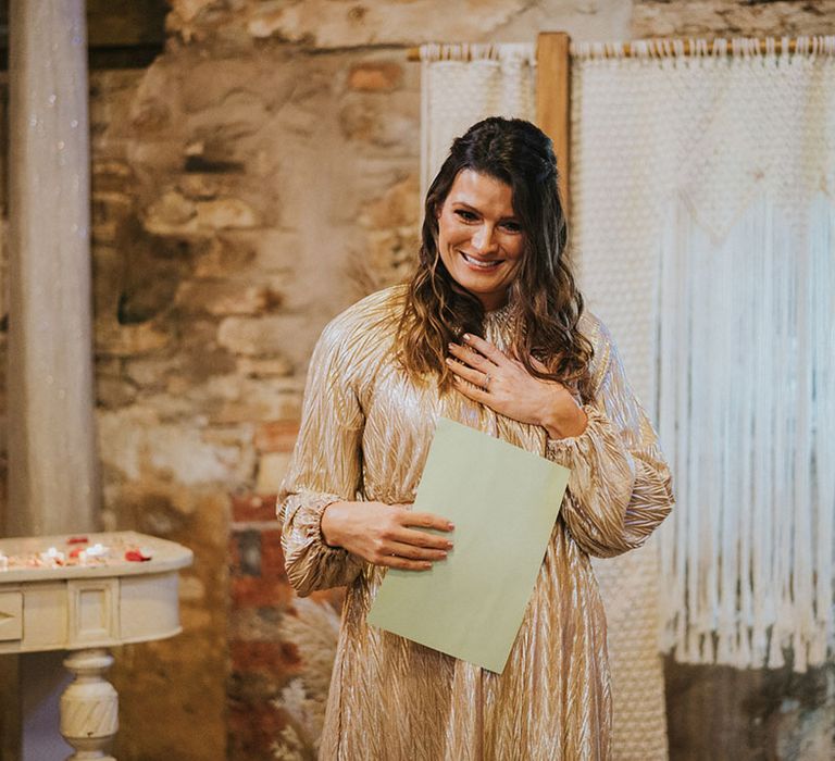 Wedding guest in stunning gold outfit reads out their speech