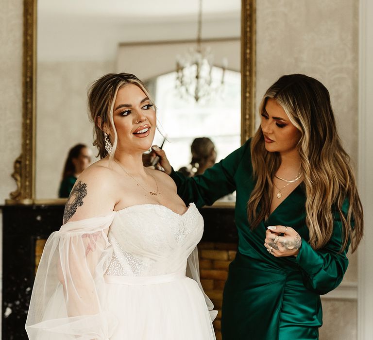 YouTube star Jamie Genevieve helps the bride with some body makeup as she wears custom strapless wedding dress with sheer sleeves