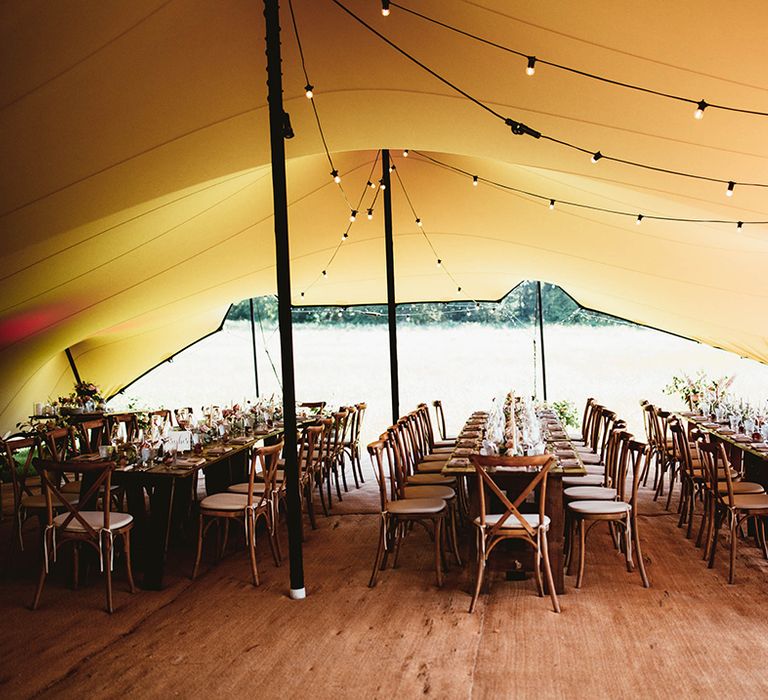 Stretch tent canopy over wedding reception banquet tables with fairy lights 