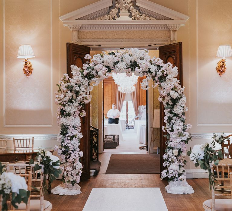 Classic country house wedding venue with pink and white flower wedding arch 