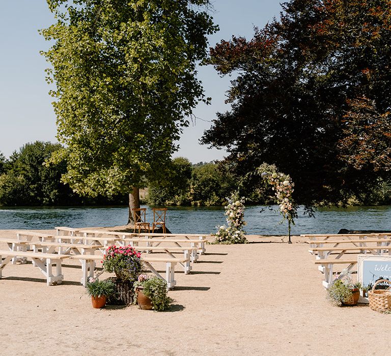 Outdoor wedding ceremony on the bank of the River Thames complete with floral archway 