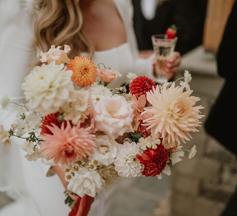 Red, pink, white and peach roses and dahlia wedding bouquet