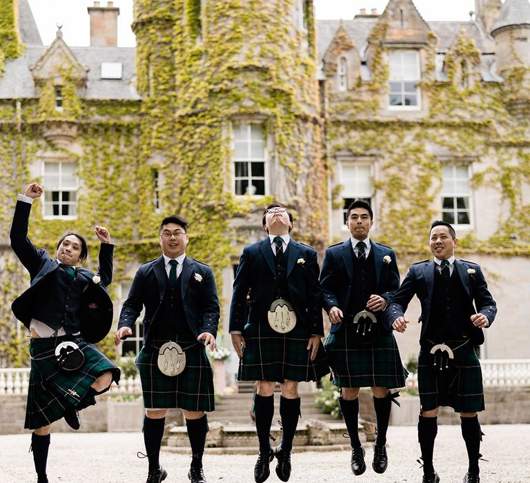 Groom & his groomsmen jump in the air whilst wearing kilts 